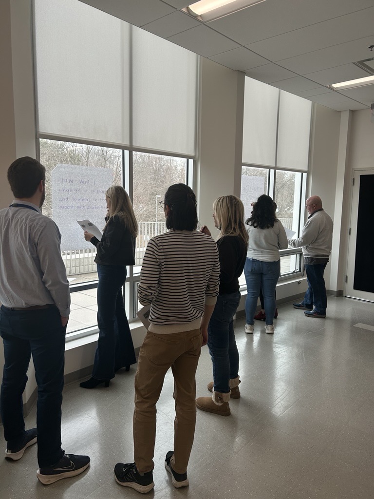 educators brainstorming in a hallway near windows