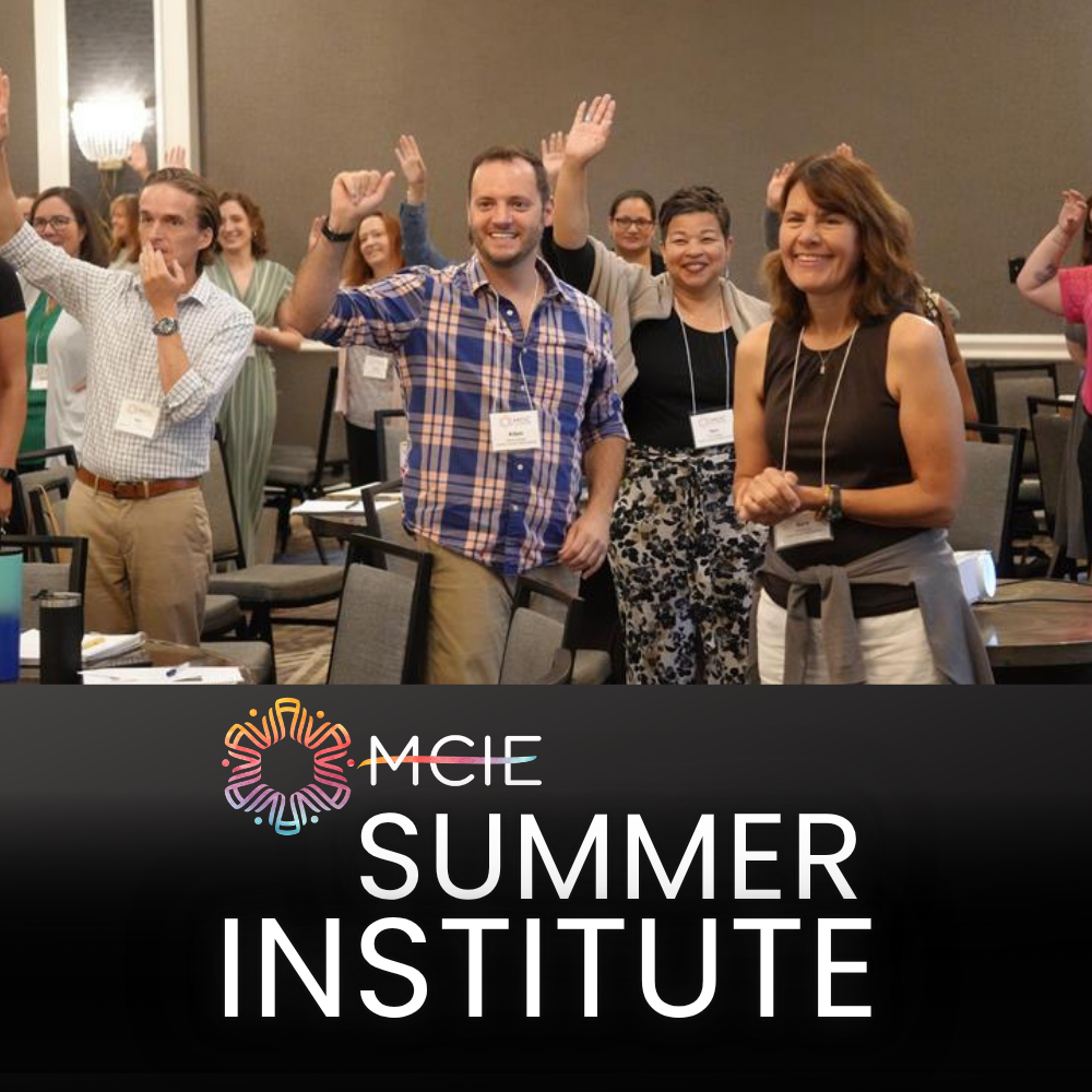 People in a crowd clapping during the Summer Institute