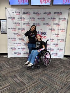 Jenna and Emma Rufo in front of an abilities expo banner